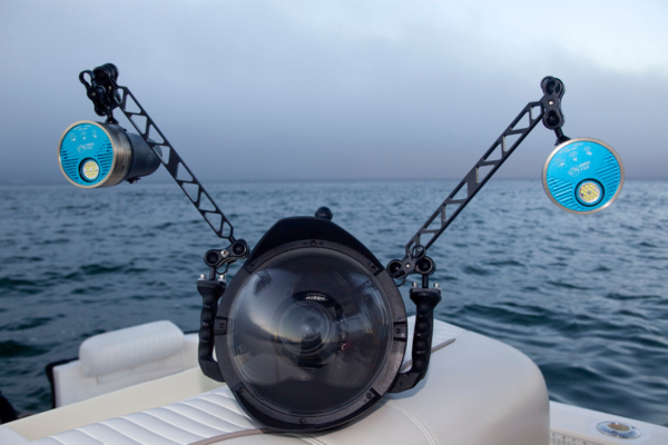 DSLR camera with underwater housing resting on a sofa aboard a boat at sea