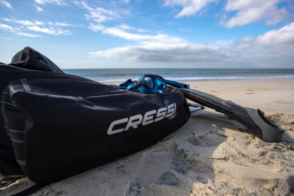 Cressi drybag and mask on a beach