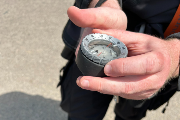 Diver being shown how a Suunto Compass works