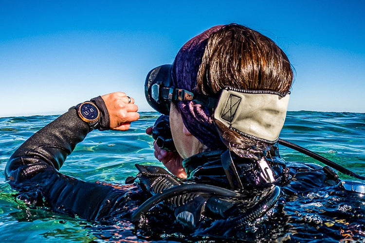 Diver at the surface checking a wrist dive computer