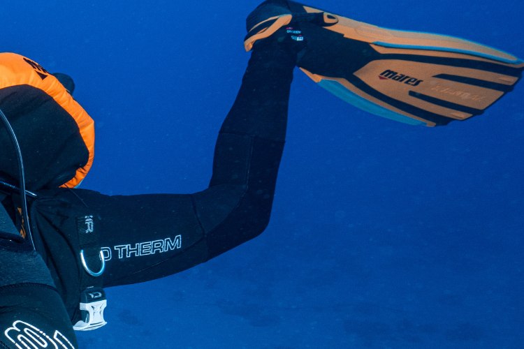 Diver finning underwater in open-heel fins