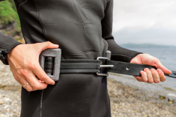 Diver or Freediver putting on weight belt and weights